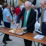 Weihbischof Scharl teilt seinen Brotlaib mit allen im Garten Versammelten