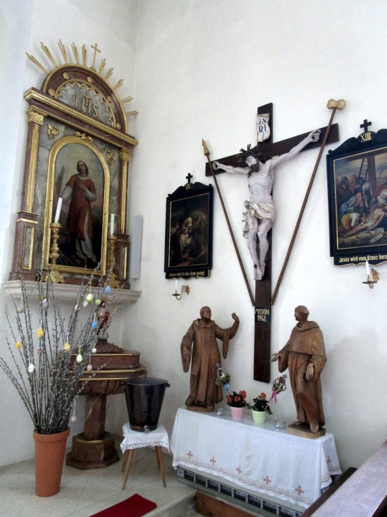 Kruzifix aus dem 17. Jahrhundert und Bild des Hl. Vinzenz oberhalb vom Taufbecken