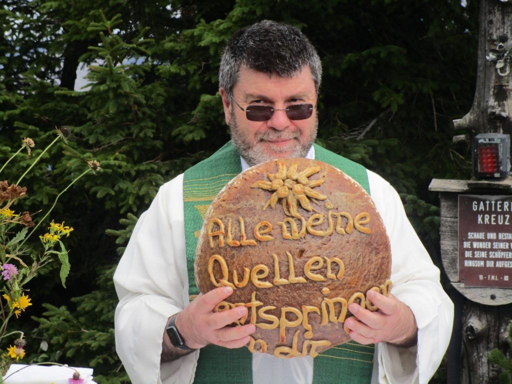 Der gesegnete Brotlaib wird mit sichtbarer Freude erhoben