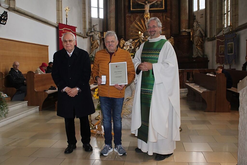 Johann Trimmel mit Ehrenzeichen in Silber sowie Pfarrer Thomas Marosch und Vikariatsobmann Wilhelm Weiss